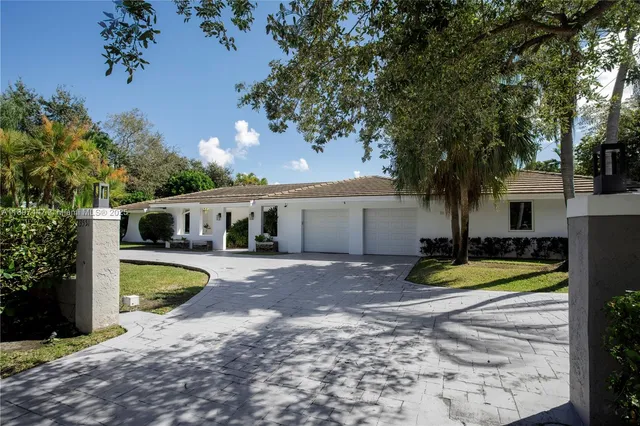a front view of a house with swimming pool and trees
