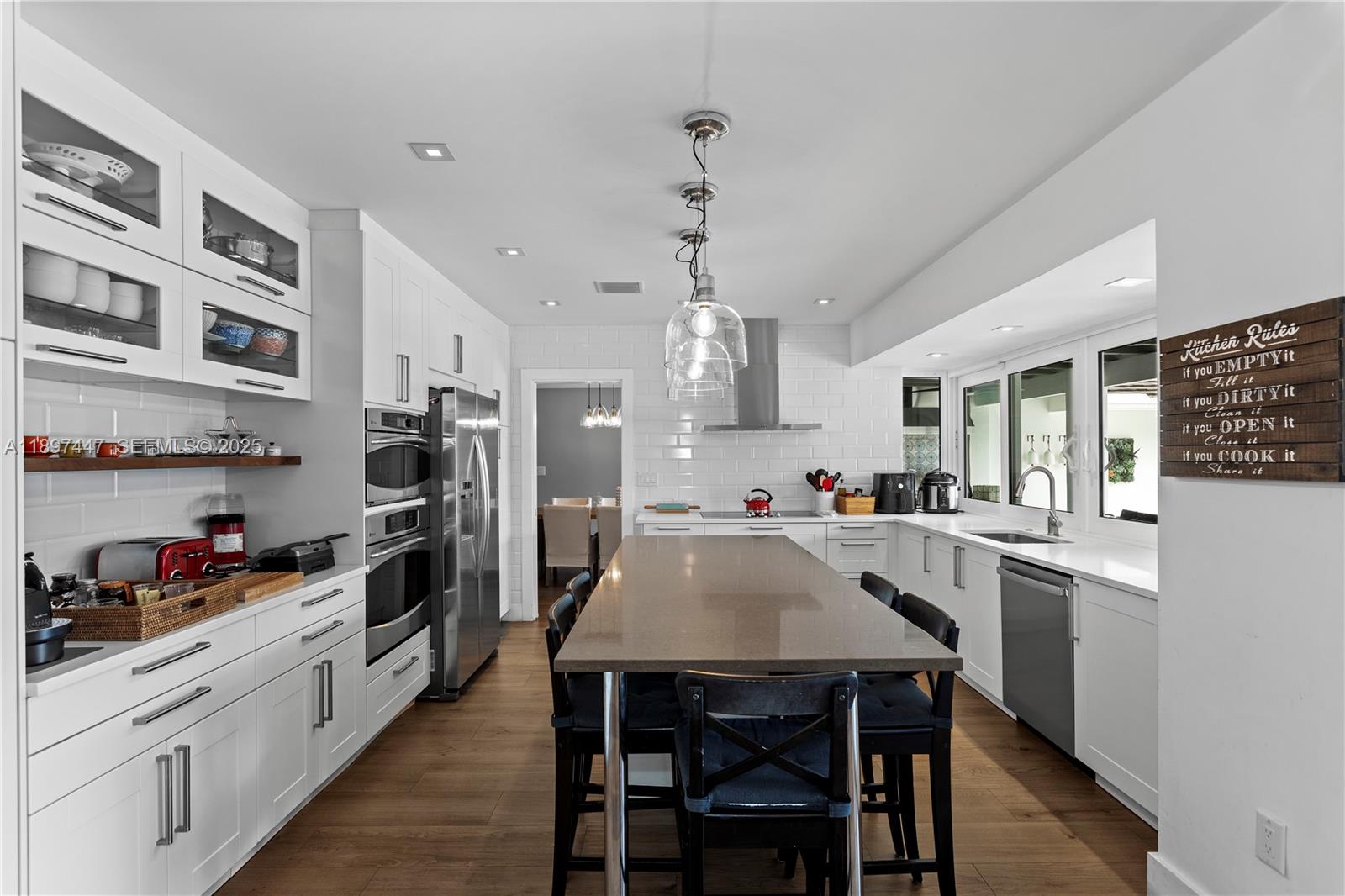13551 Southwest 62nd Avenue Pinecrest, FL 33156 - Photo 20 of 70 a kitchen with stainless steel appliances a table and chairs in it