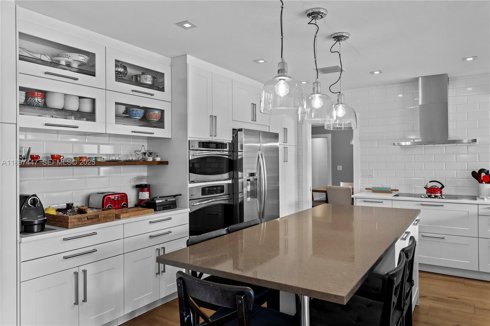 13551 Southwest 62nd Avenue Pinecrest, FL 33156 - Photo 21 of 70 a kitchen with stainless steel appliances a dining table chairs refrigerator and cabinets