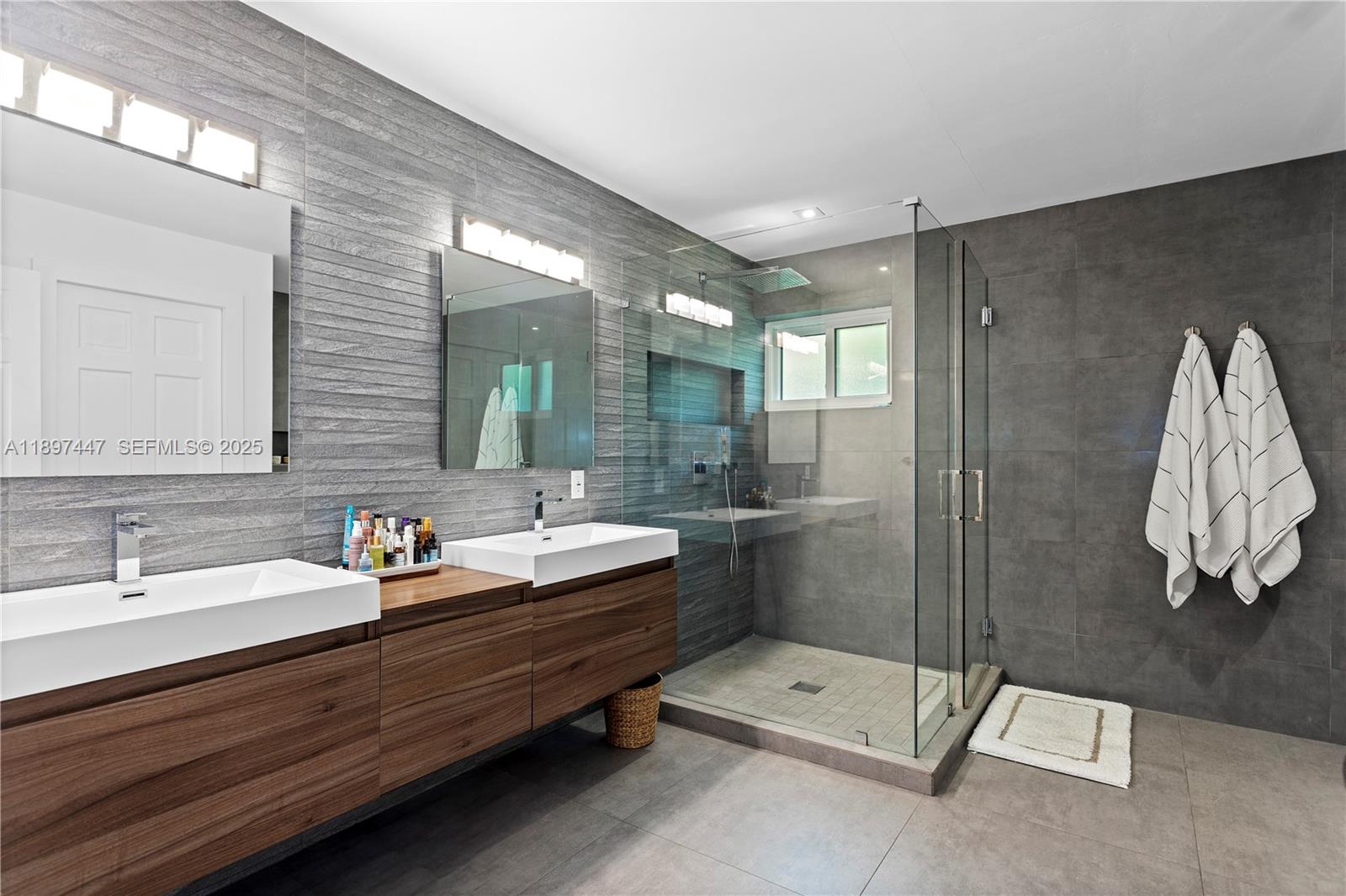 13551 Southwest 62nd Avenue Pinecrest, FL 33156 - Photo 33 of 70 a bathroom with a double vanity sink mirror and shower