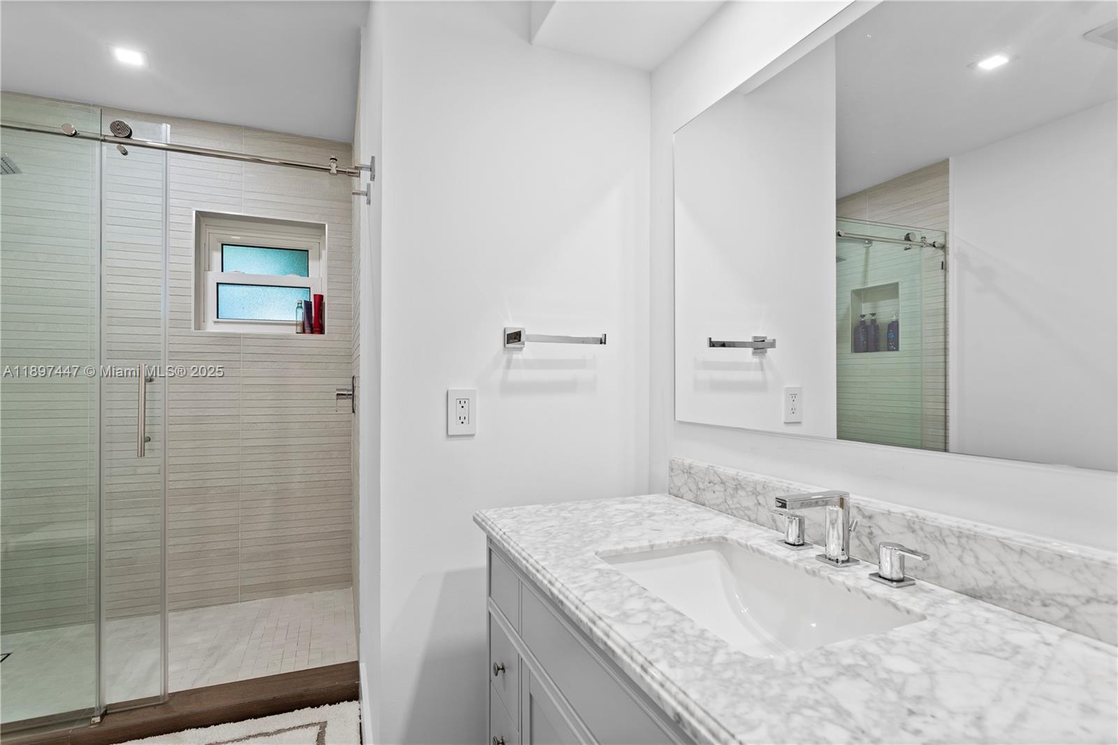 13551 Southwest 62nd Avenue Pinecrest, FL 33156 - Photo 39 of 70 a bathroom with a granite countertop sink a mirror and shower