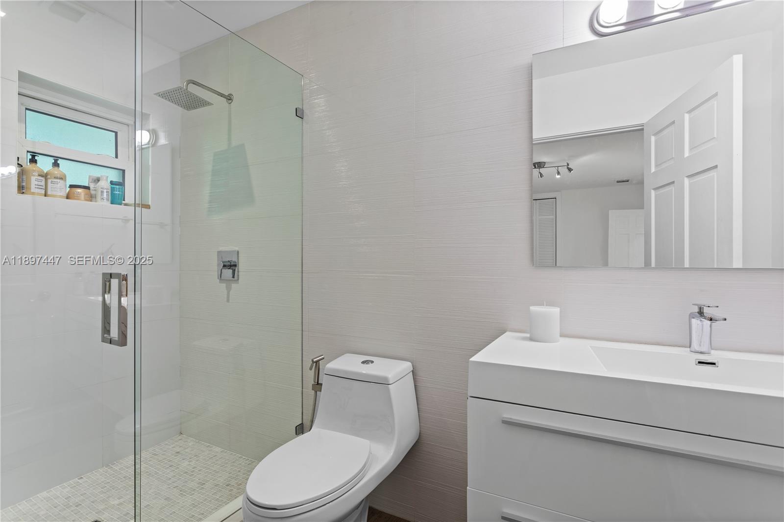 13551 Southwest 62nd Avenue Pinecrest, FL 33156 - Photo 41 of 70 a bathroom with a toilet sink shower and mirror