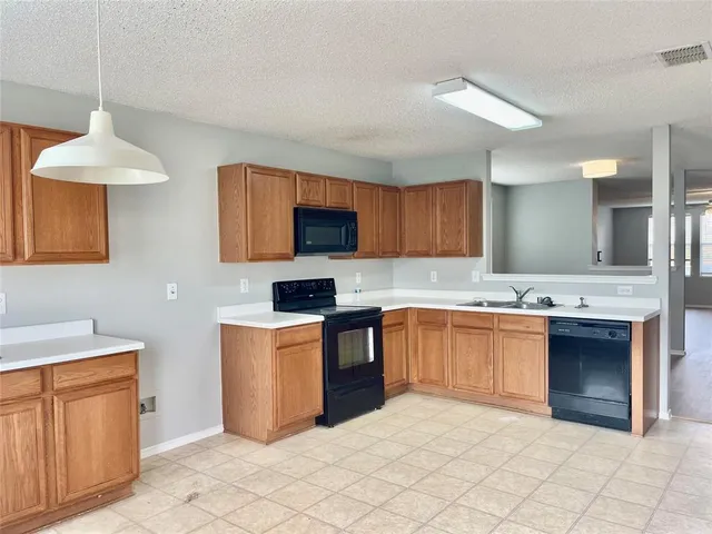 a kitchen with granite countertop a stove top oven sink and cabinets