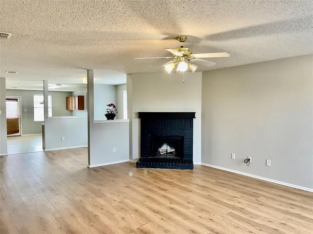a view of an empty room with a fireplace and fan