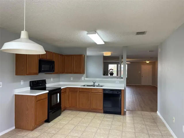 a kitchen with a sink a stove and cabinets