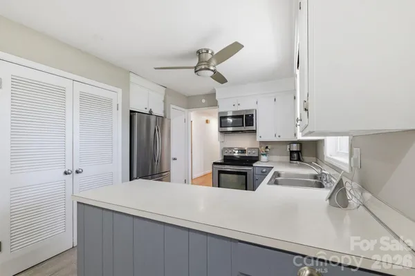 a kitchen with stainless steel appliances a sink stove refrigerator and cabinets
