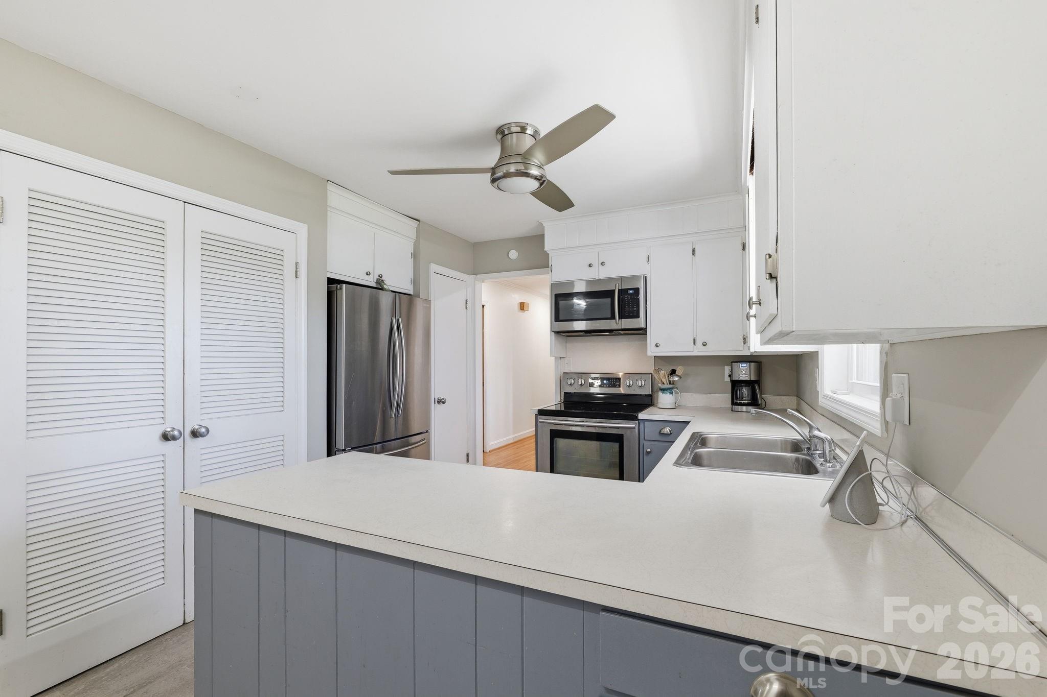 11715 Timber Ridge Road Charlotte, NC 28213 - Photo 13 of 38 a kitchen with stainless steel appliances a sink stove refrigerator and cabinets