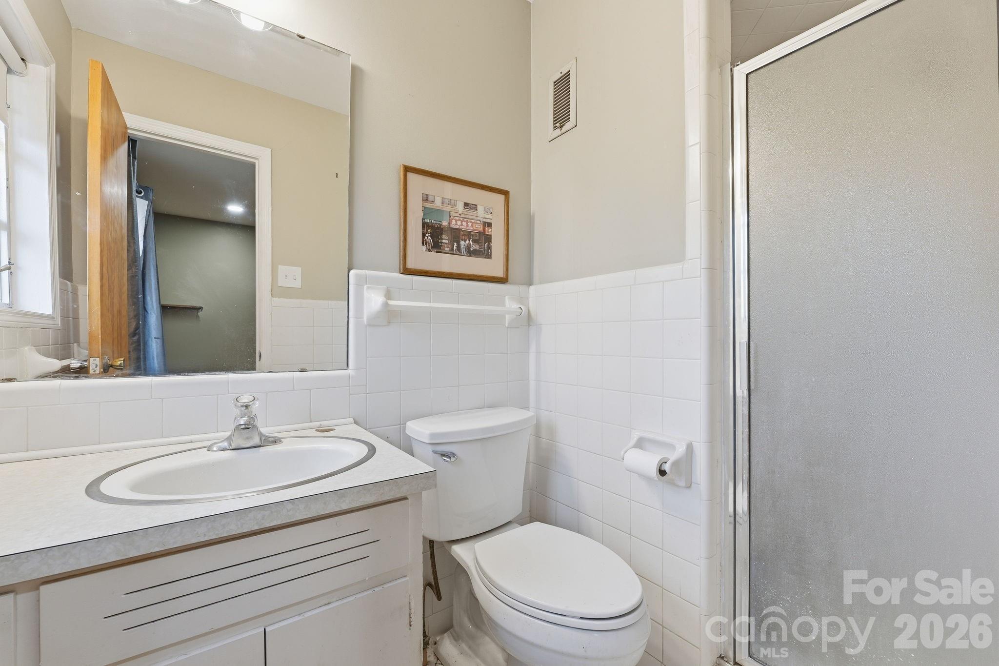 11715 Timber Ridge Road Charlotte, NC 28213 - Photo 26 of 38 a bathroom with a granite countertop sink a toilet and a mirror