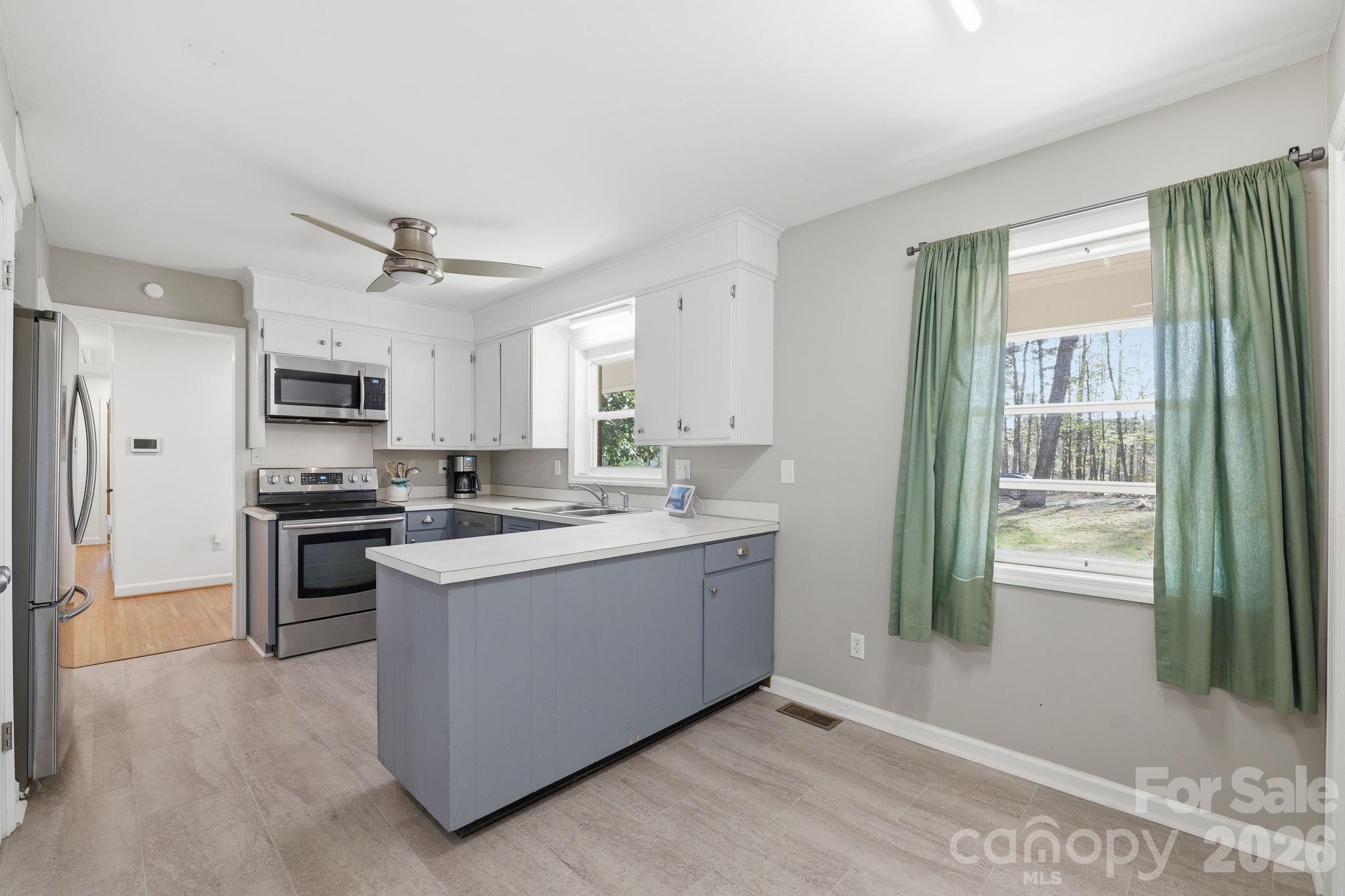 11715 Timber Ridge Road Charlotte, NC 28213 - Photo 10 of 38 a kitchen with stainless steel appliances granite countertop a stove top oven a sink and a refrigerator