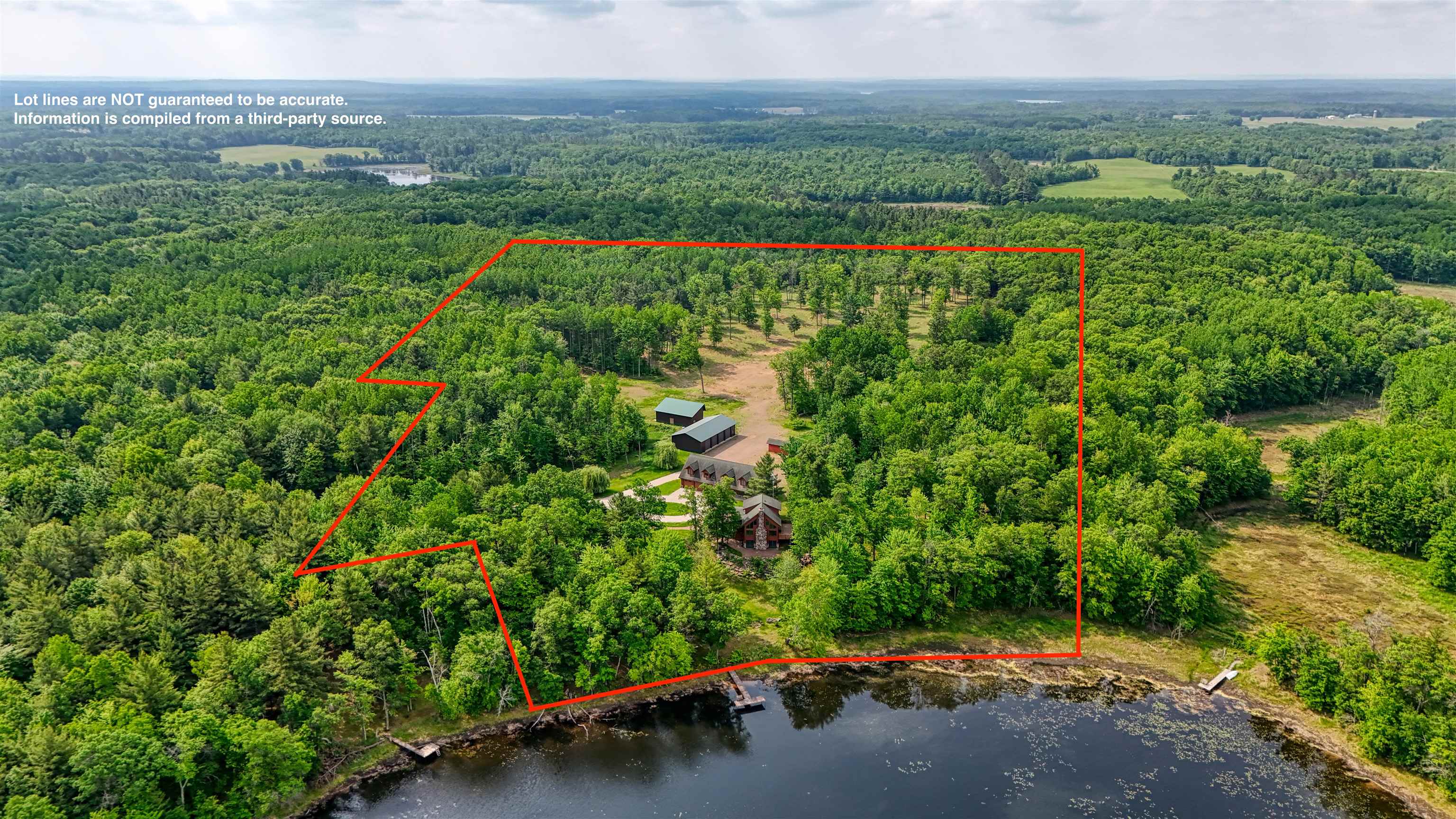1881 County Road A Spooner, WI 54801 - Photo 13 of 54 Aerial view of property and surrounding area with a forest, property boundaries highlighted, and a nearby body of water