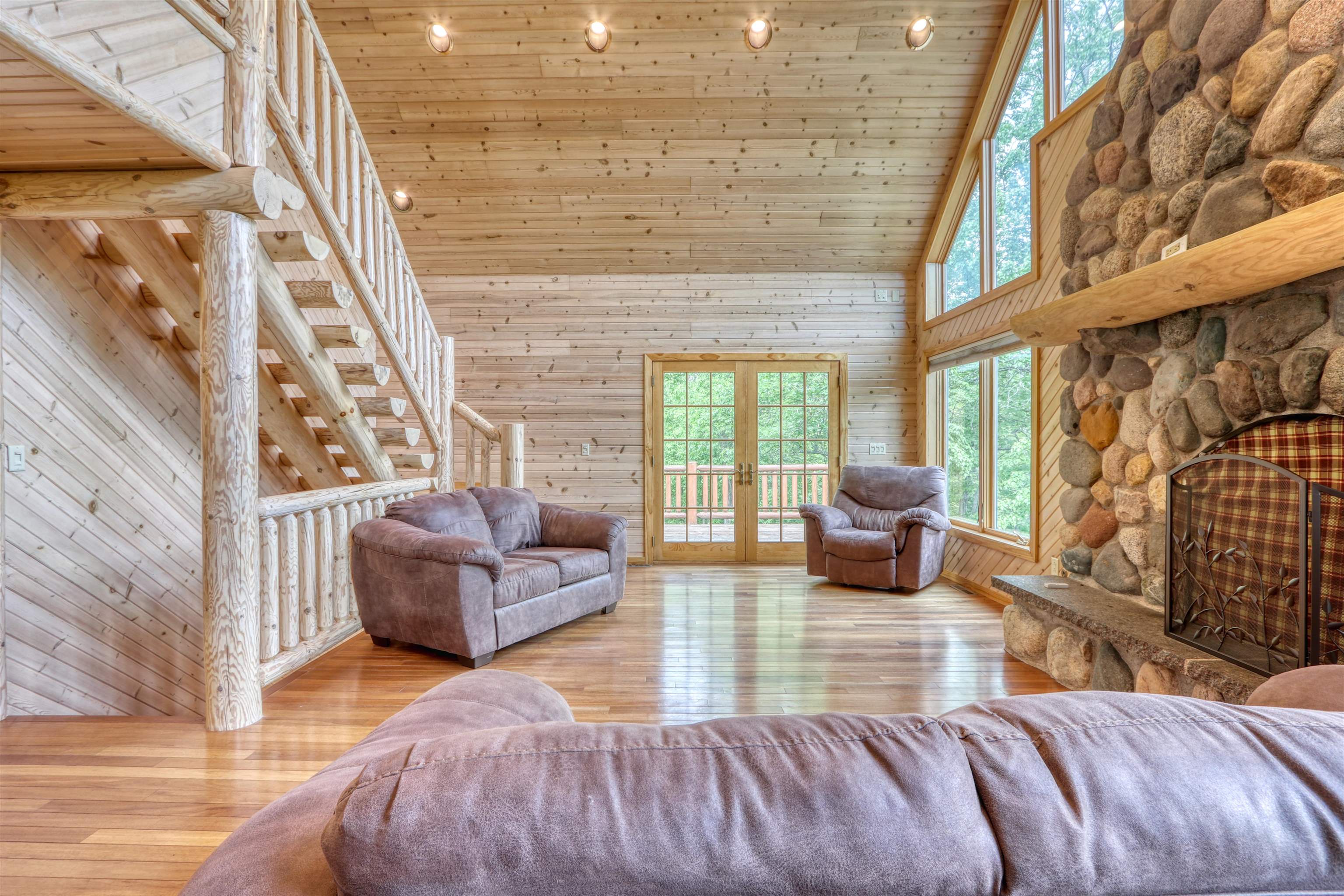 1881 County Road A Spooner, WI 54801 - Photo 21 of 54 Living area with high vaulted ceiling, french doors, wood walls, wood finished floors, and wood ceiling
