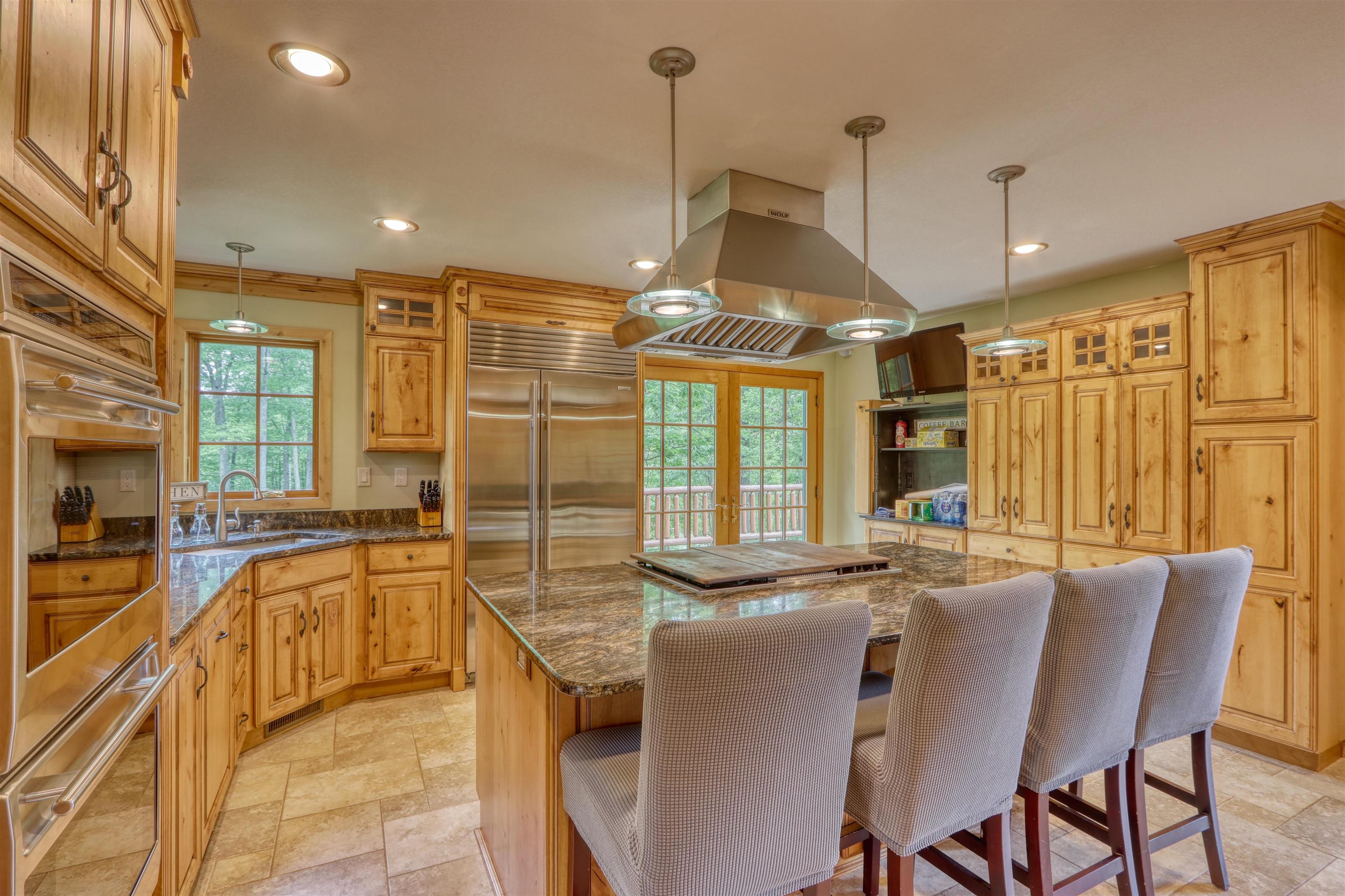 1881 County Road A Spooner, WI 54801 - Photo 24 of 54 Kitchen featuring a sink, island exhaust hood, a center island, appliances with stainless steel finishes, and light stone finish flooring