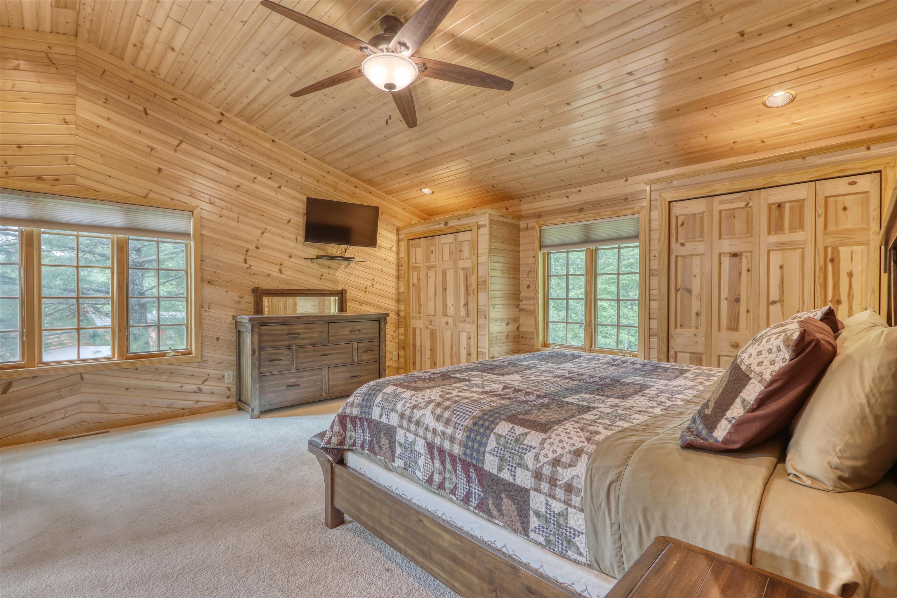 1881 County Road A Spooner, WI 54801 - Photo 32 of 54 Bedroom with wooden walls, wooden ceiling, carpet floors, lofted ceiling, and ceiling fan