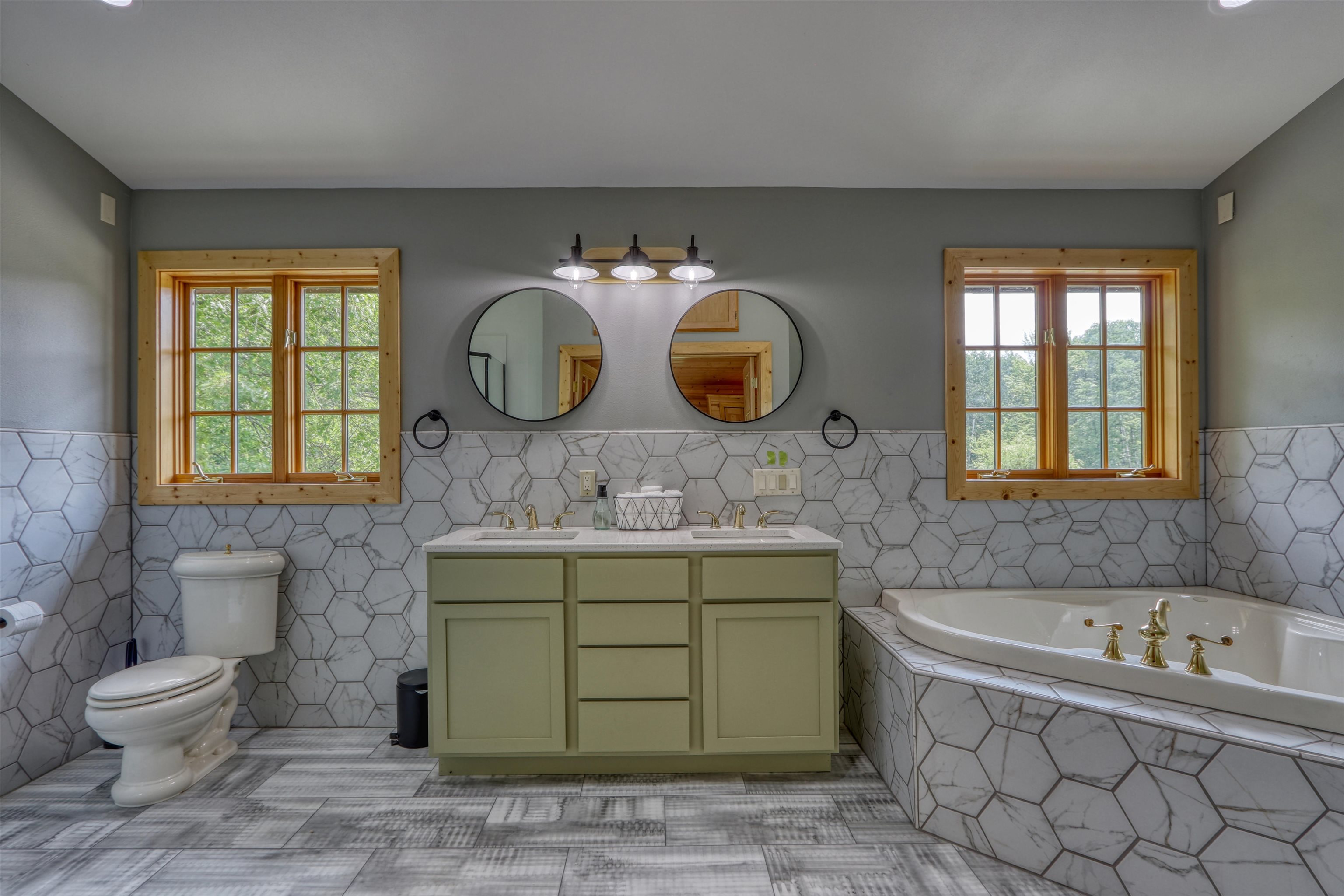 1881 County Road A Spooner, WI 54801 - Photo 35 of 54 Full bathroom with tile walls, double vanity, a bath, toilet, and wainscoting