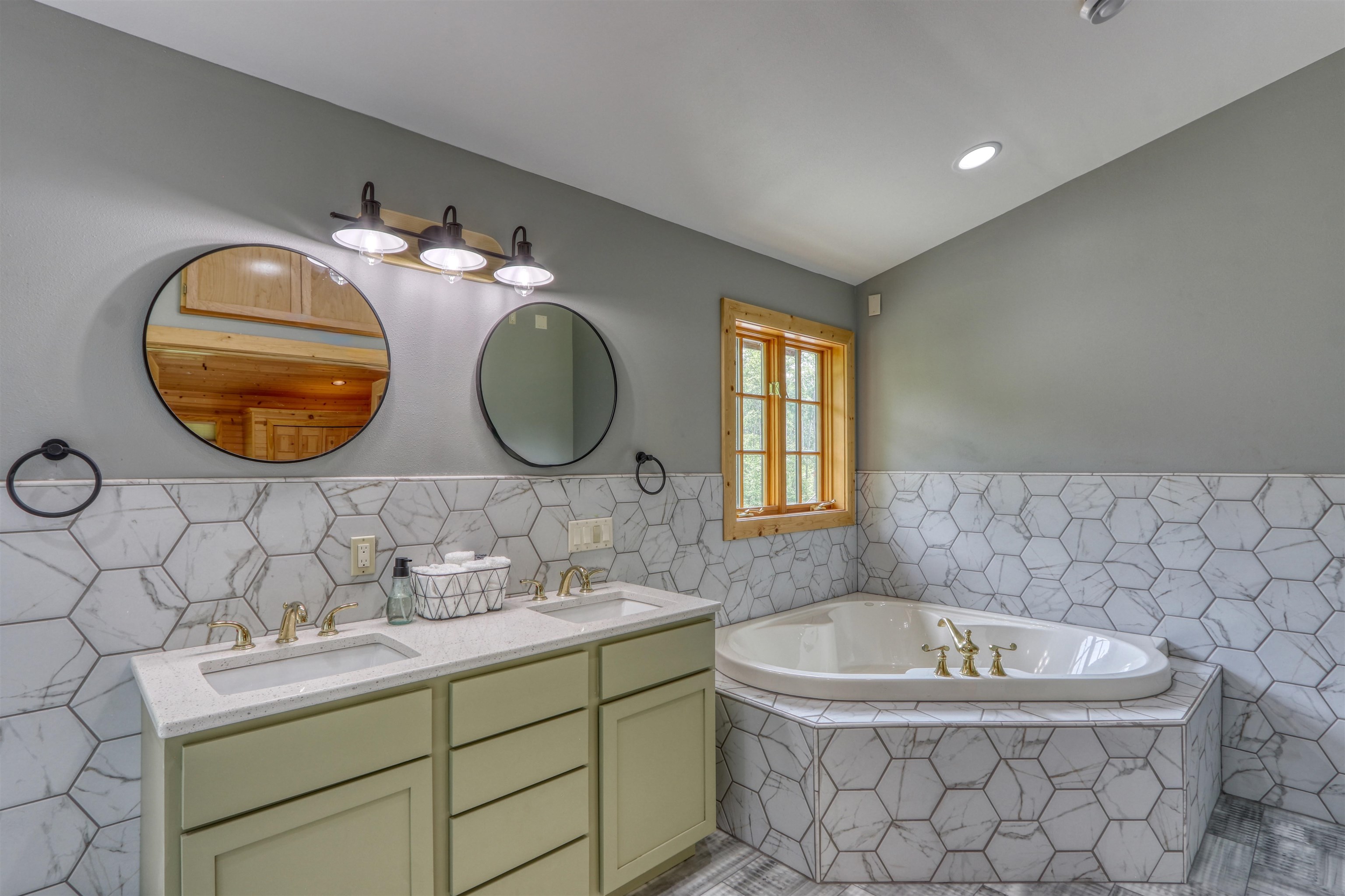 1881 County Road A Spooner, WI 54801 - Photo 37 of 54 Bathroom featuring tile walls, double vanity, a bath, wainscoting, and tile patterned flooring