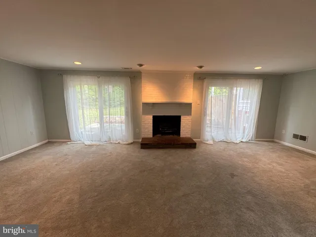 an empty room with fireplace and windows
