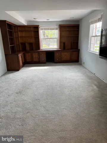 an empty room with a fireplace and windows