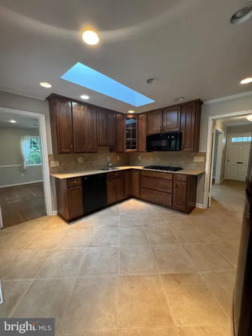 a large kitchen with a large counter top and stainless steel appliances
