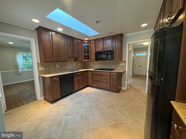 a large kitchen with stainless steel appliances granite countertop a sink and cabinets