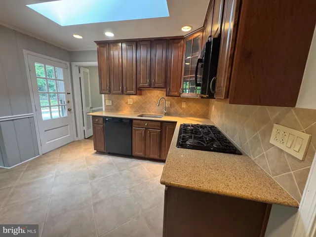 a kitchen with stainless steel appliances granite countertop a sink and a stove