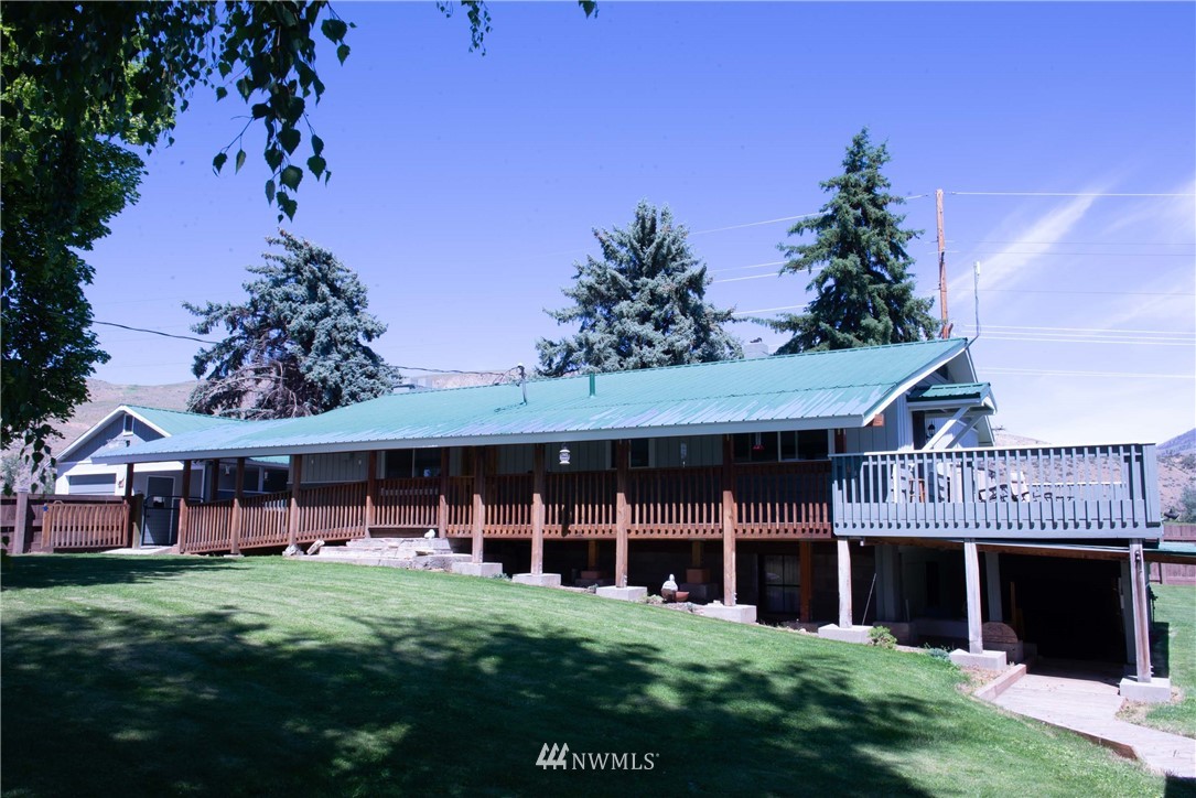 78 Mundy Road Twisp, WA 98856 - Photo 30 of 40 a view of a brick house with a big yard and large trees