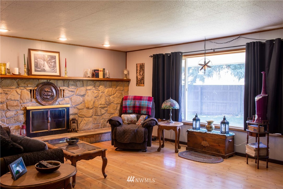 78 Mundy Road Twisp, WA 98856 - Photo 10 of 40 a living room with furniture a fireplace and a large window