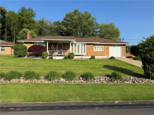 a front view of a house with a garden