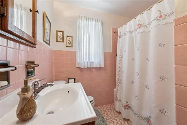 a bathroom with a sink a toilet and shower curtain