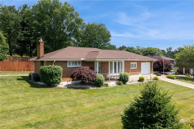 a front view of a house with yard and green space