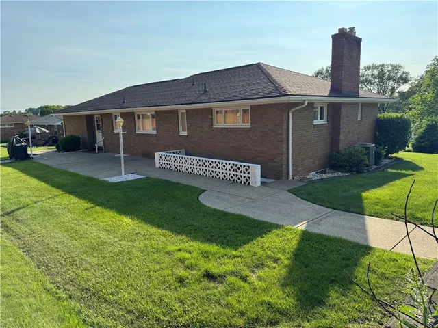 a front view of a house with a yard and outdoor seating