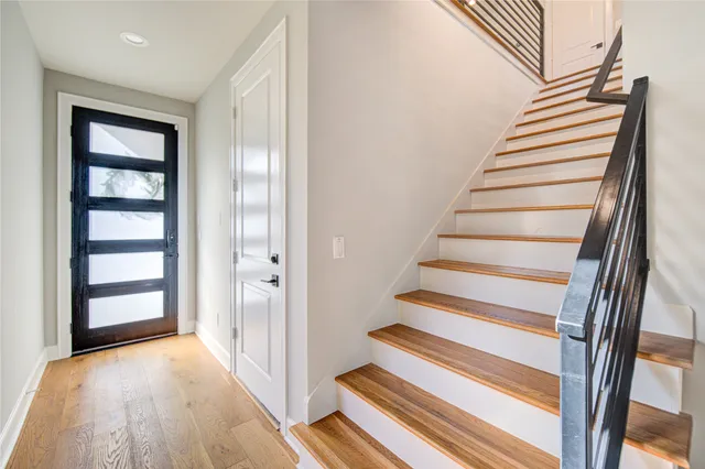 a view of entryway with wooden floor and front door