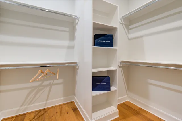 a view of a hallway with wooden floor and glass door