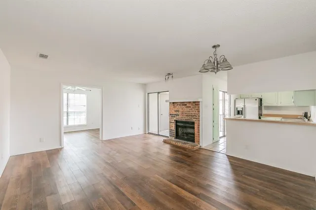 a view of empty room with wooden floor and fireplace