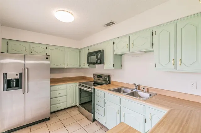 a kitchen with a sink appliances and cabinets