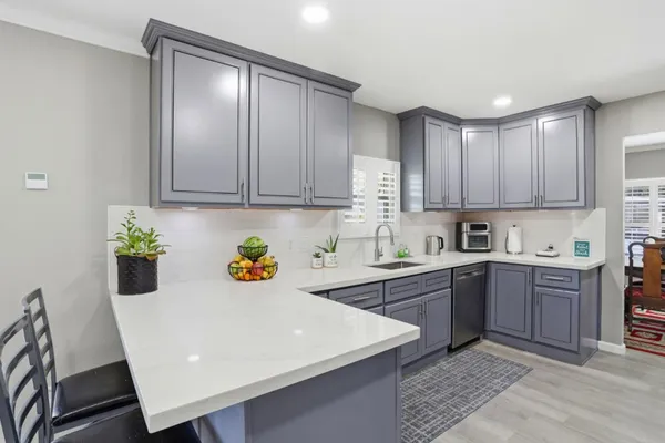 a kitchen with a sink a stove and cabinets