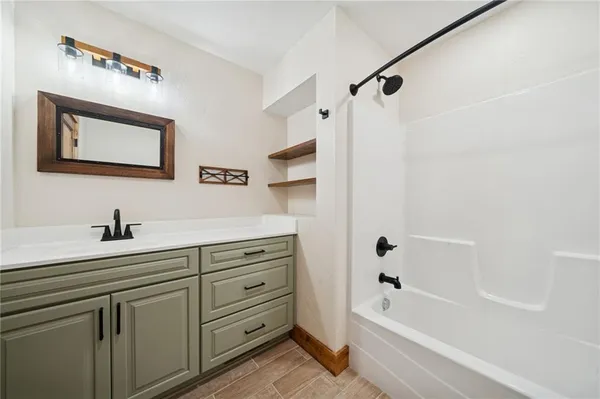 a bathroom with a tub sink and mirror