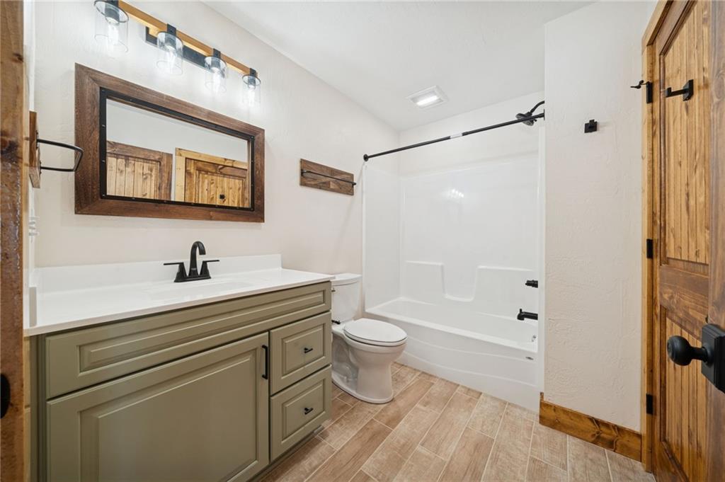 223 Deer Fern Drive Somerset, PA 15501 - Photo 25 of 37 a bathroom with a granite countertop sink a toilet a shower and a mirror