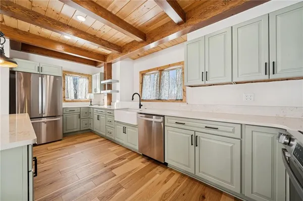 a kitchen with a sink cabinets stainless steel appliances and a window