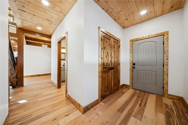 a view of a hallway with bathroom and wooden floor