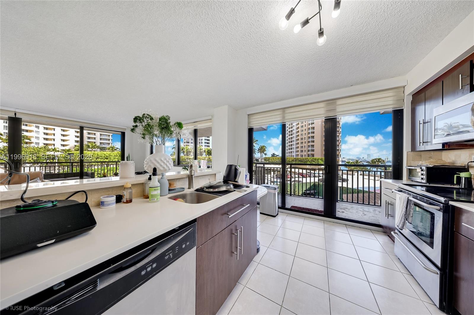 540 Brickell Key Drive, Unit 608 Miami, FL 33131 - Photo 11 of 15 a kitchen with a sink stove and cabinets