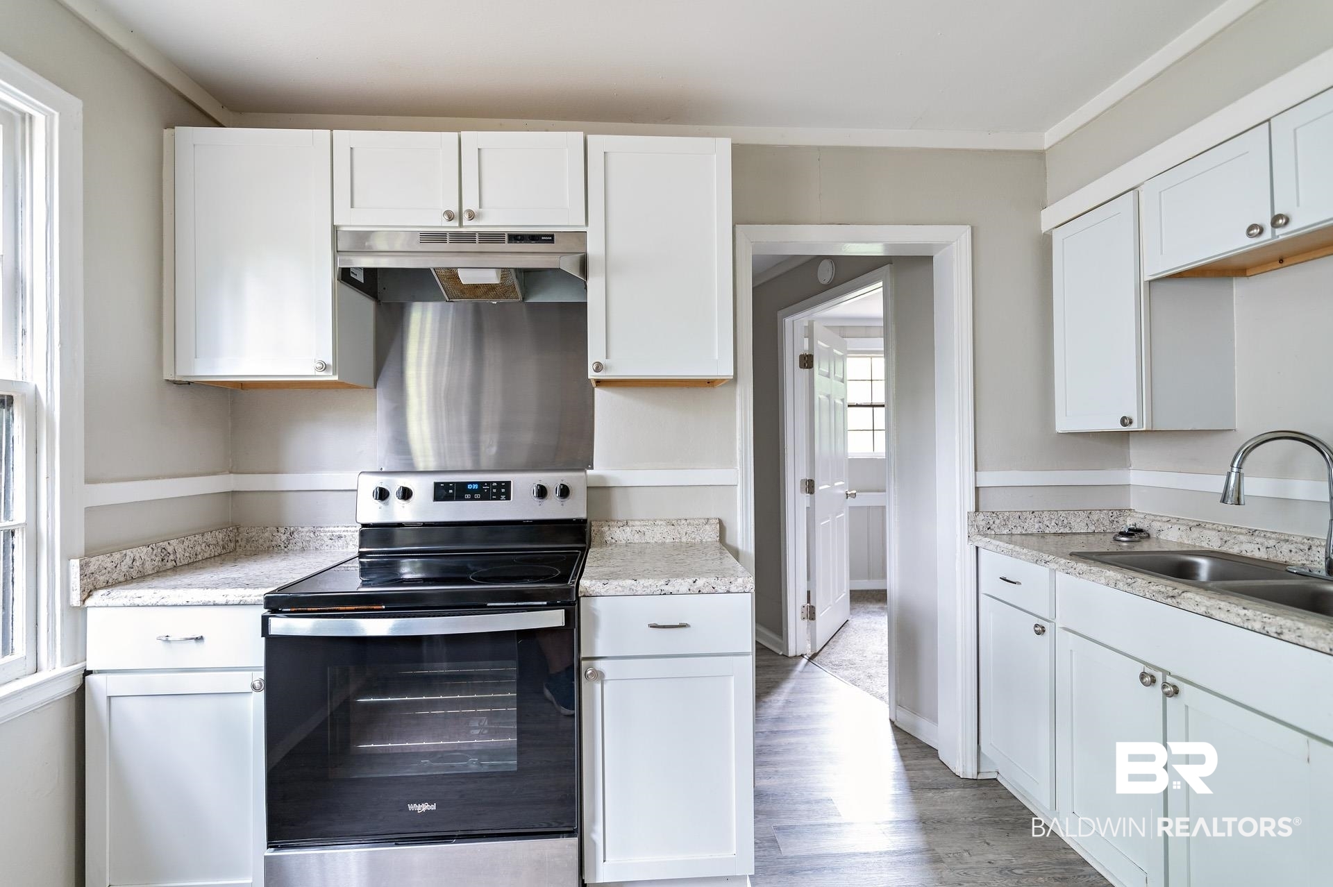 1869 Mott Drive West Mobile, AL 36617 - Photo 10 of 34 Kitchen with white cabinetry, stainless steel electric stove, under cabinet range hood, and a sink