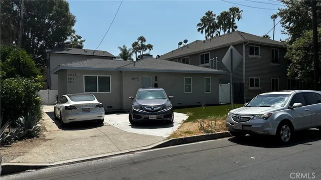 a front view of a house with cars