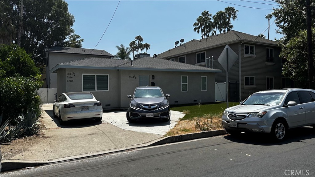 a front view of a house with cars