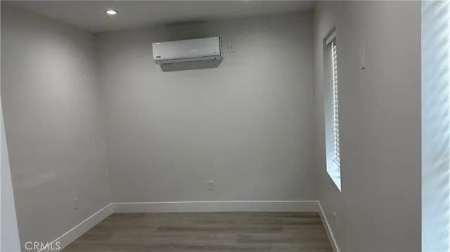 an empty room with wooden floor and entrance