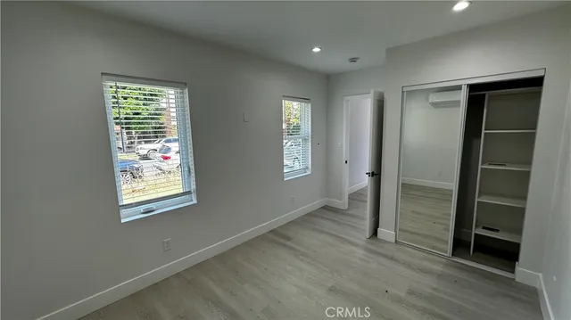 an empty room with wooden floor and a window