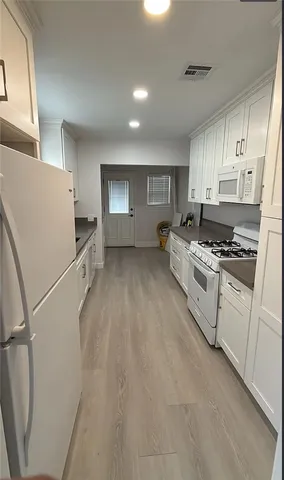 a kitchen with white cabinets and white appliances