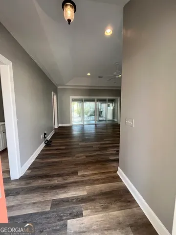 a view of a hallway with wooden floor and staircase