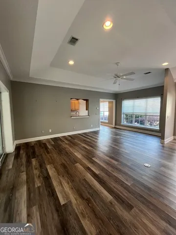 a view of a room with wooden floor and ceiling fan