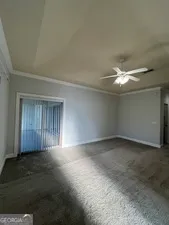 an empty room with a window and ceiling fan