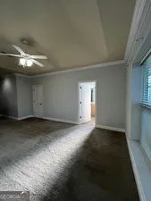 an empty room with a ceiling fan and closet